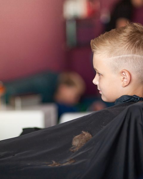 A,Little,Cute,Boy,Sits,In,A,Hairdresser's,At,The
